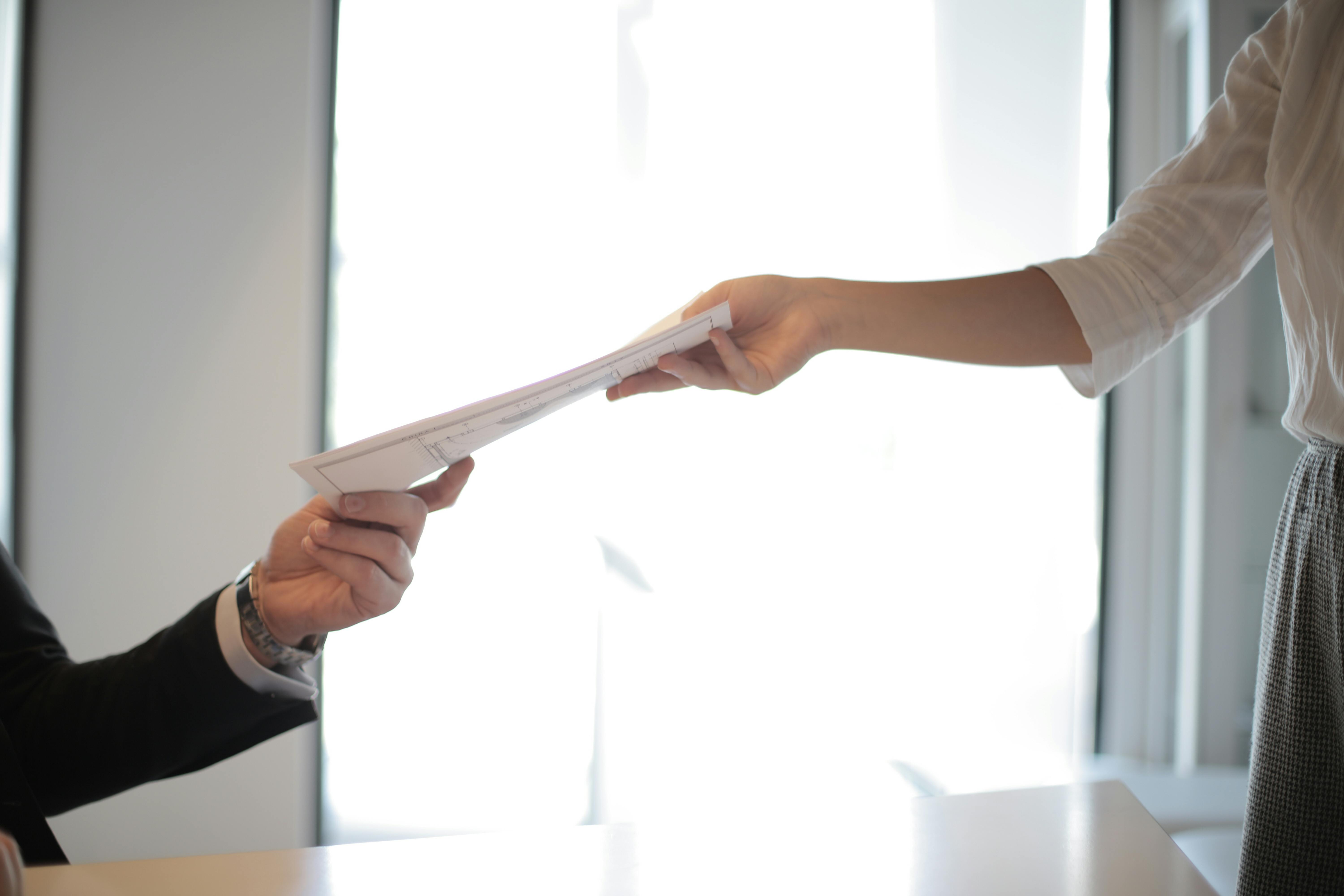 woman handing a man some documents